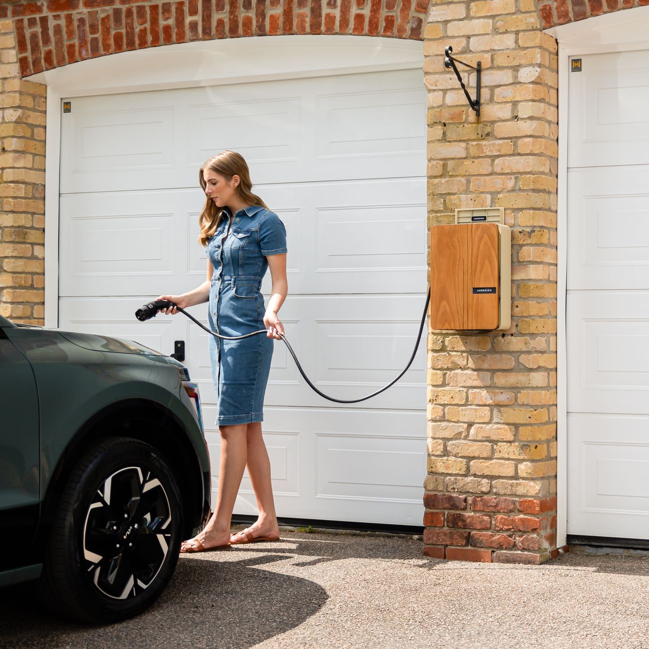 Electric vehicle charger on a driveway wall